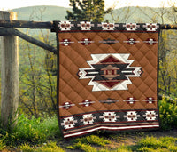 Brown quilt suspended on outdoor post with Native geometric banding and central star motif