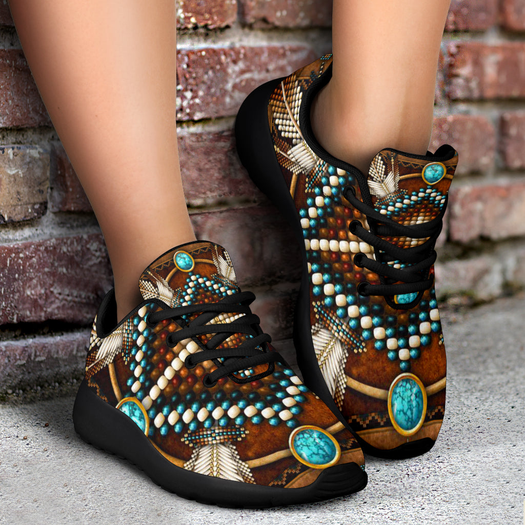 Brown multicolor lace-up sneakers on pavement, turquoise oval badges, black rubber sole