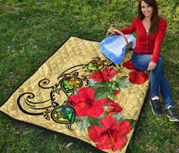 Beige quilt showing black turtle motif, green turtles, and red hibiscus flower prints