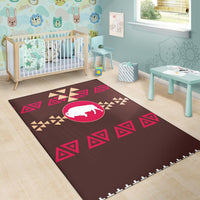 Brown children’s style area rug with white bison in pink oval and red geometric triangles