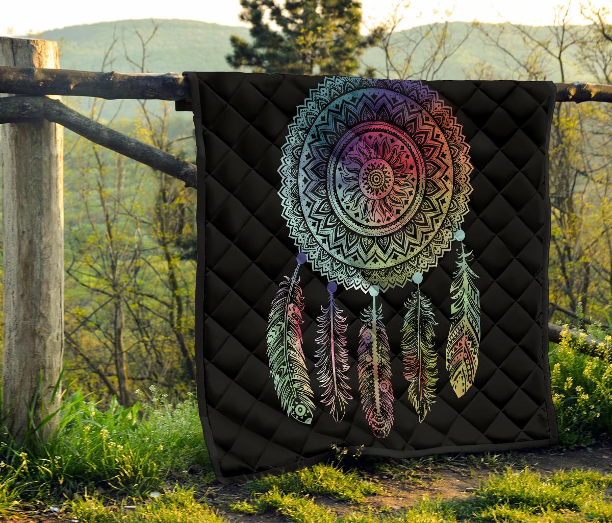 Black quilt mounted outdoors with multicolor mandala dreamcatcher and feather graphic