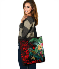 Front view of black tote bag with teal turtle, red tribal design, tropical hibiscus blooms.