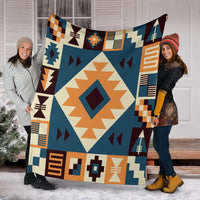 Navy arrow pattern blanket held by two people, cream diamond center with orange and maroon shapes