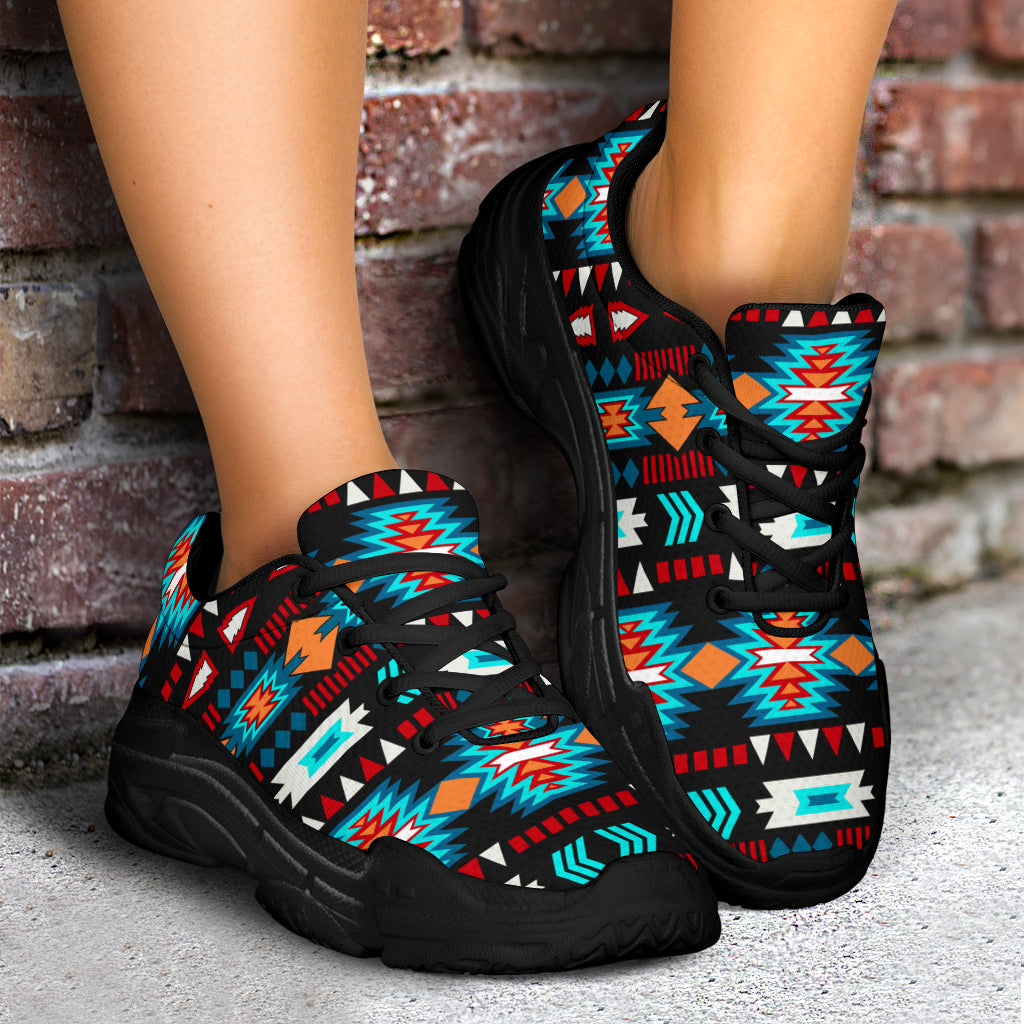 Black chunky lace-up sneakers with neon blue Aztec-style pattern, shown with full pair on feet