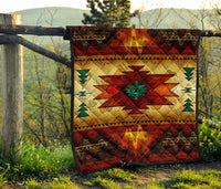 Quilt displayed on outdoor railing: red and gold geometric star center with green trim points