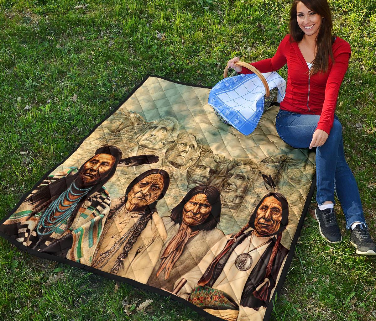 Quilt corner view on grass showing Native American portraits and multicolor bead-and-feather details