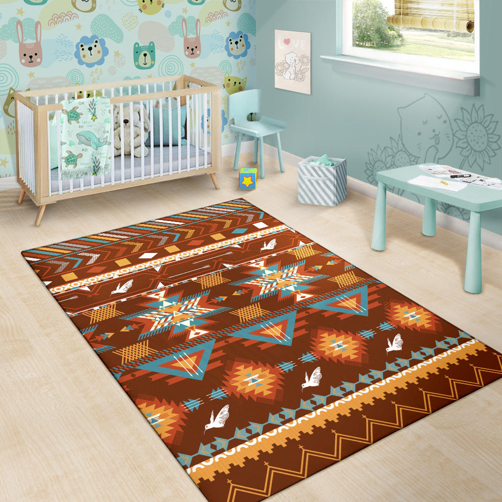 Kids area rug in brown with colorful aztec-style triangles and white bird motifs