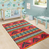Red geometric area rug with tribal animal motifs and colorful horizontal stripe patterns
