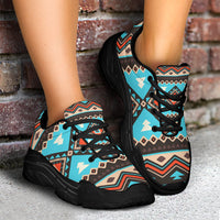 Low-angle view of turquoise geometric print chunky sneakers with black laces and sole