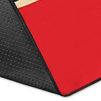 Corner close-up of red area rug with black textured backing and red stitched edge