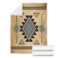 Tan patterned blanket folded with Southwestern diamond star design and stitched striped border