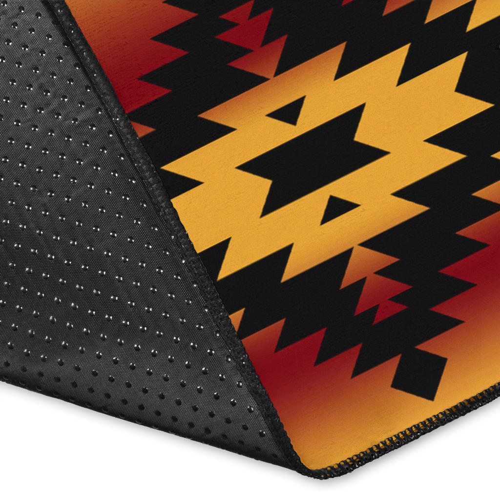 Close-up: black rug corner with yellow star, red triangles, and dotted texture