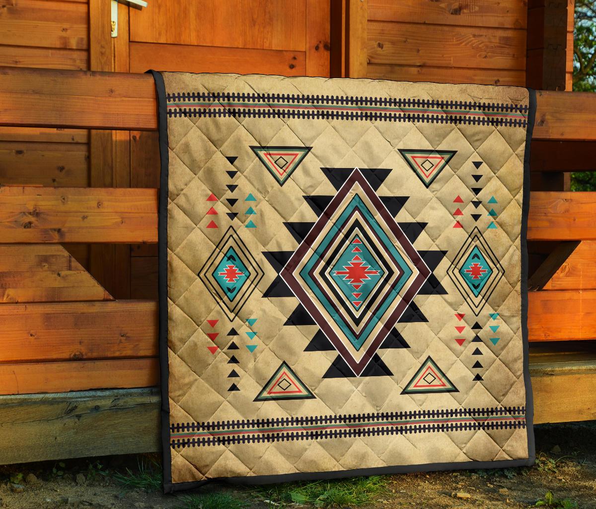 Southwest symbol quilt on porch, tan with colorful diamond motifs, central star and stitched border.