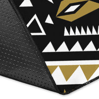 Corner close-up of black tribal rug with white and gold geometric print on textured edge