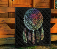 Black quilt displayed against wooden wall, showing multicolor dreamcatcher mandala and feathers