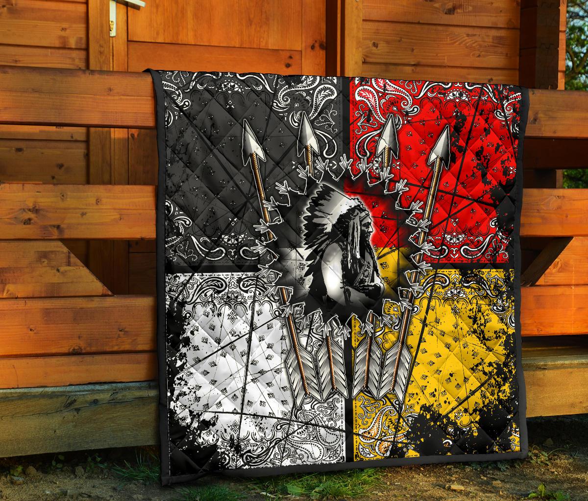Chief Arrow quilt set against wooden wall: black red yellow white ornate arrow and feather design