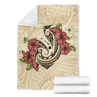 Beige blanket with fish hook and hibiscus plumeria print; folded white throw included