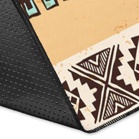 Corner view of beige tribal area rug showing black back and stitched border edge