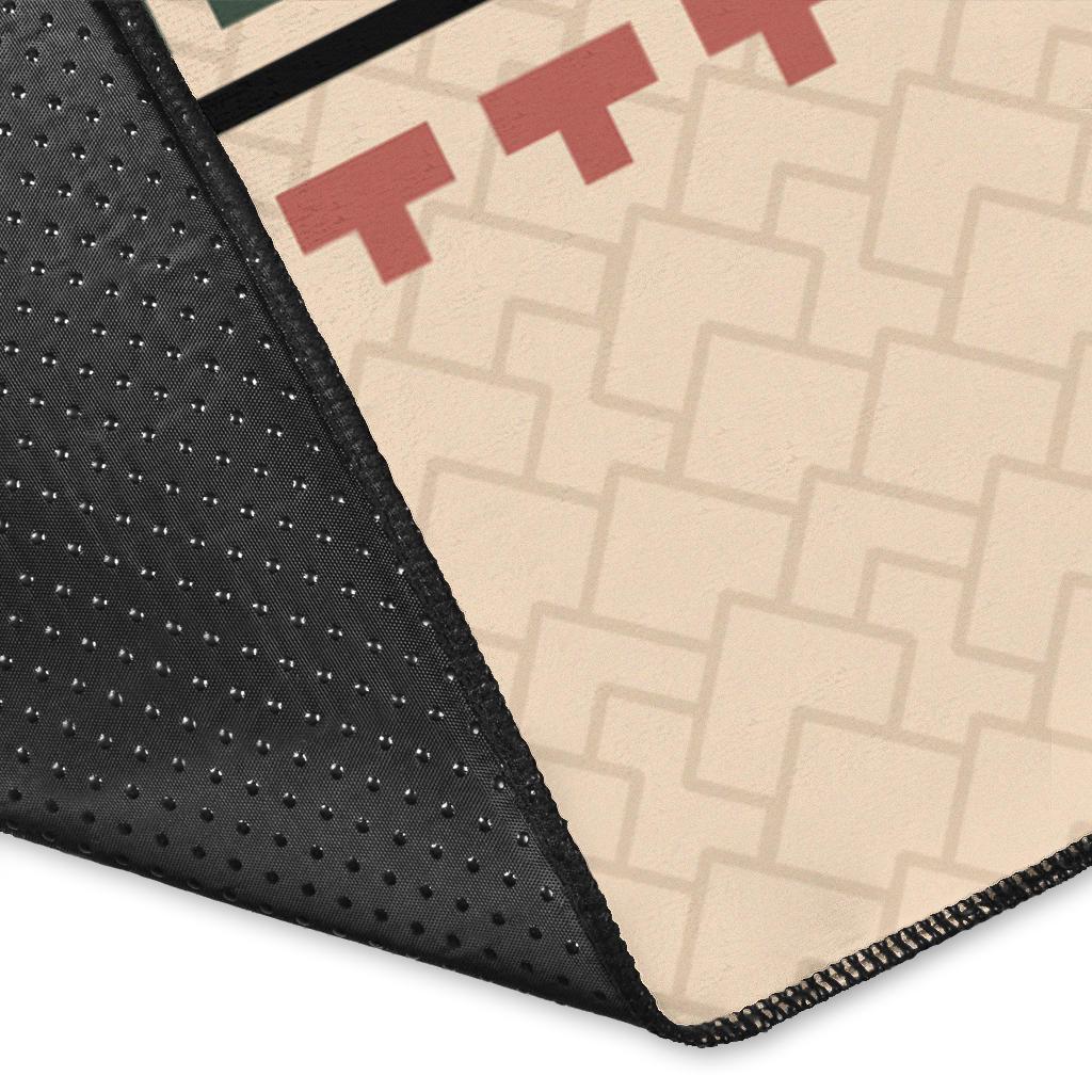 Corner close-up of black-edged beige area rug with multicolor tribal print