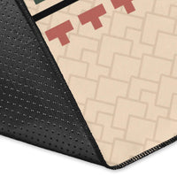 Corner close-up of black-edged beige area rug with multicolor tribal print