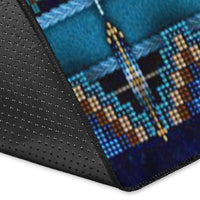 Rug corner close-up: black textured backing with blue pattern and stitched edge trim