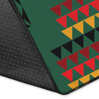 Close-up of green rug corner with dotted backing and multicolor geometric design