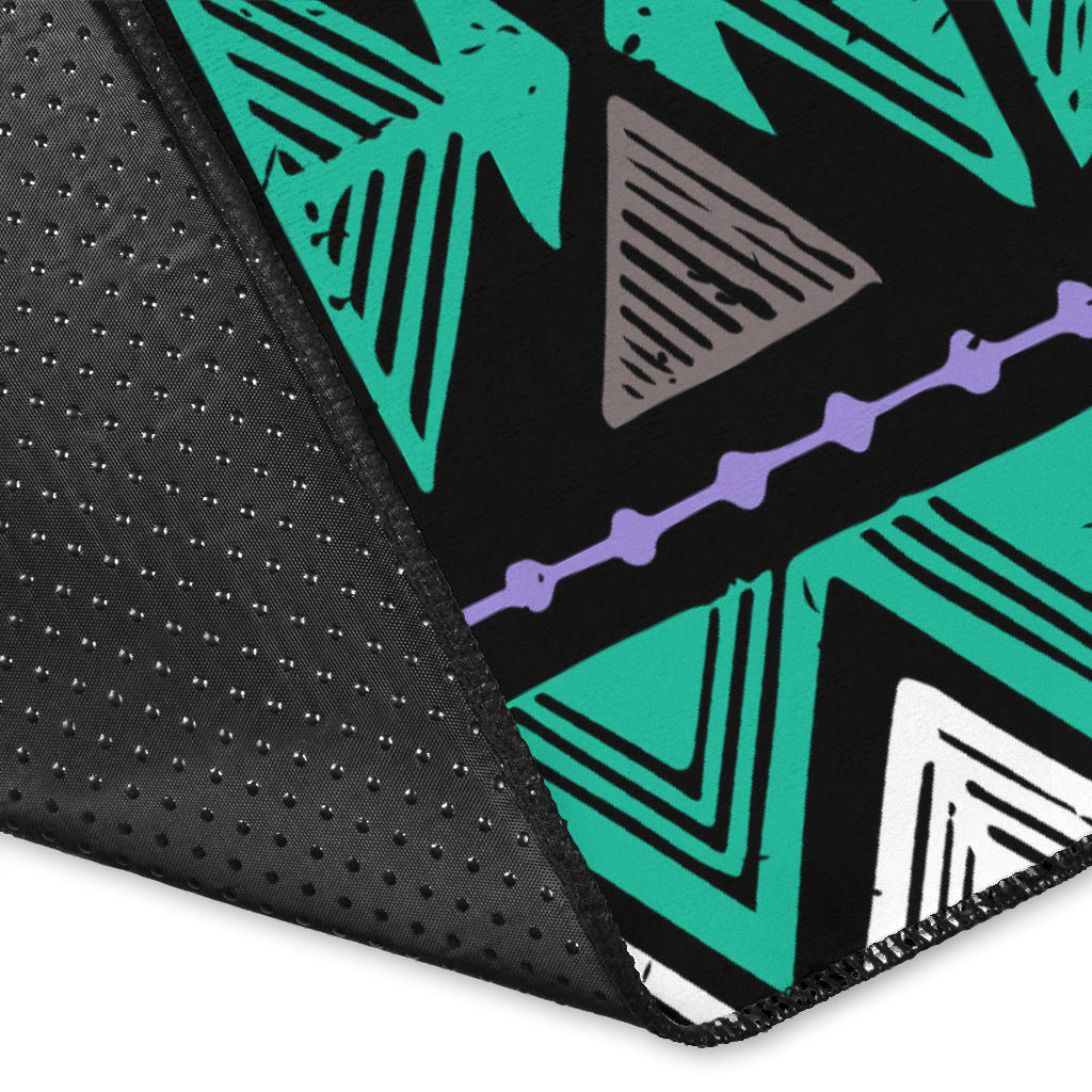 Close-up of neon tribal rug edge with dotted texture and teal, purple, white triangles