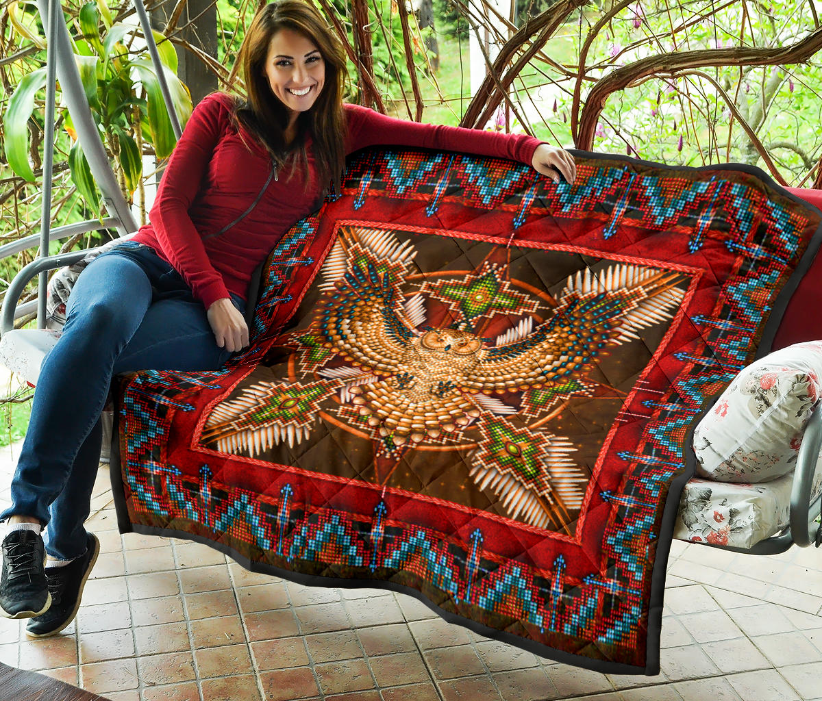 Folded red Native-style quilt with turquoise patterned border and owl medallion center
