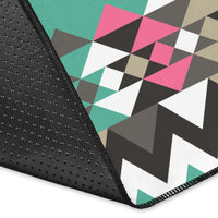 Teal geometric rug corner with black textured edge and multicolor diamond pattern
