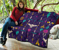 Blue quilt draped on chair, multicolor Native thunderbird geometric symbols