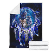 Blue dreamcatcher blanket with rolled white towels, central girl and wolf motif