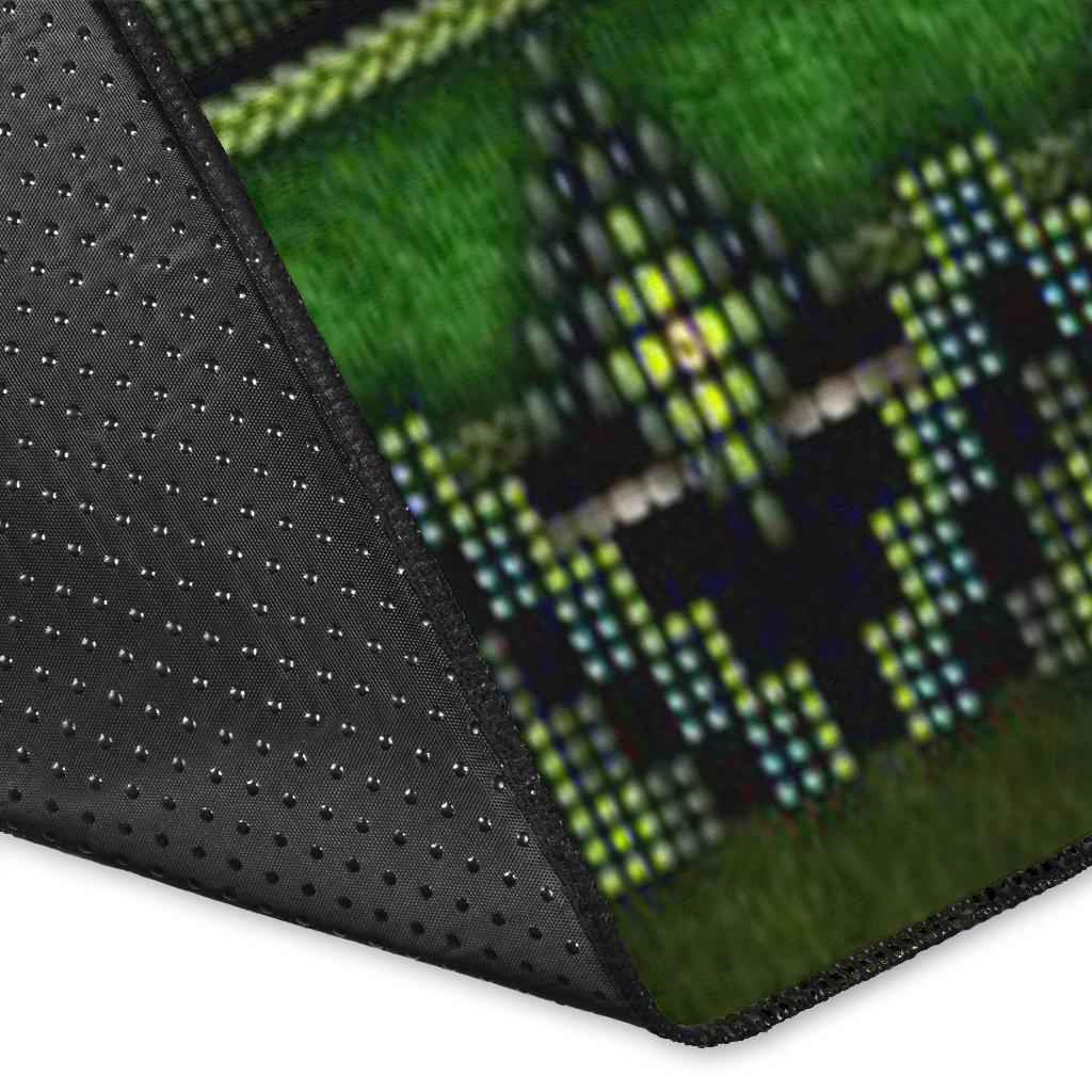 Close-up corner of green area rug with dark binding and dotted textured surface