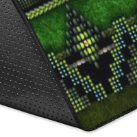 Close-up corner of green area rug with dark binding and dotted textured surface