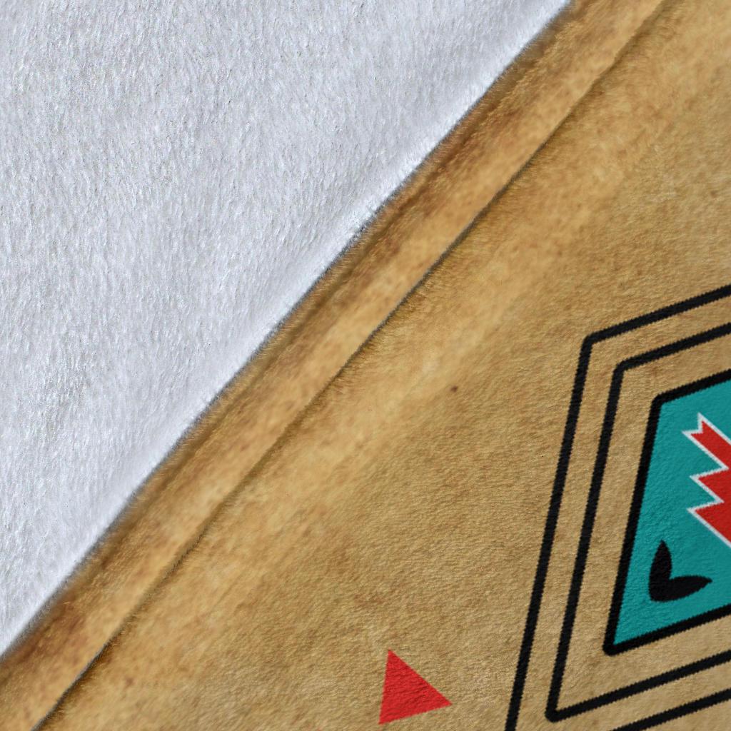 Close-up of tan blanket edge with white backing and printed geometric border line