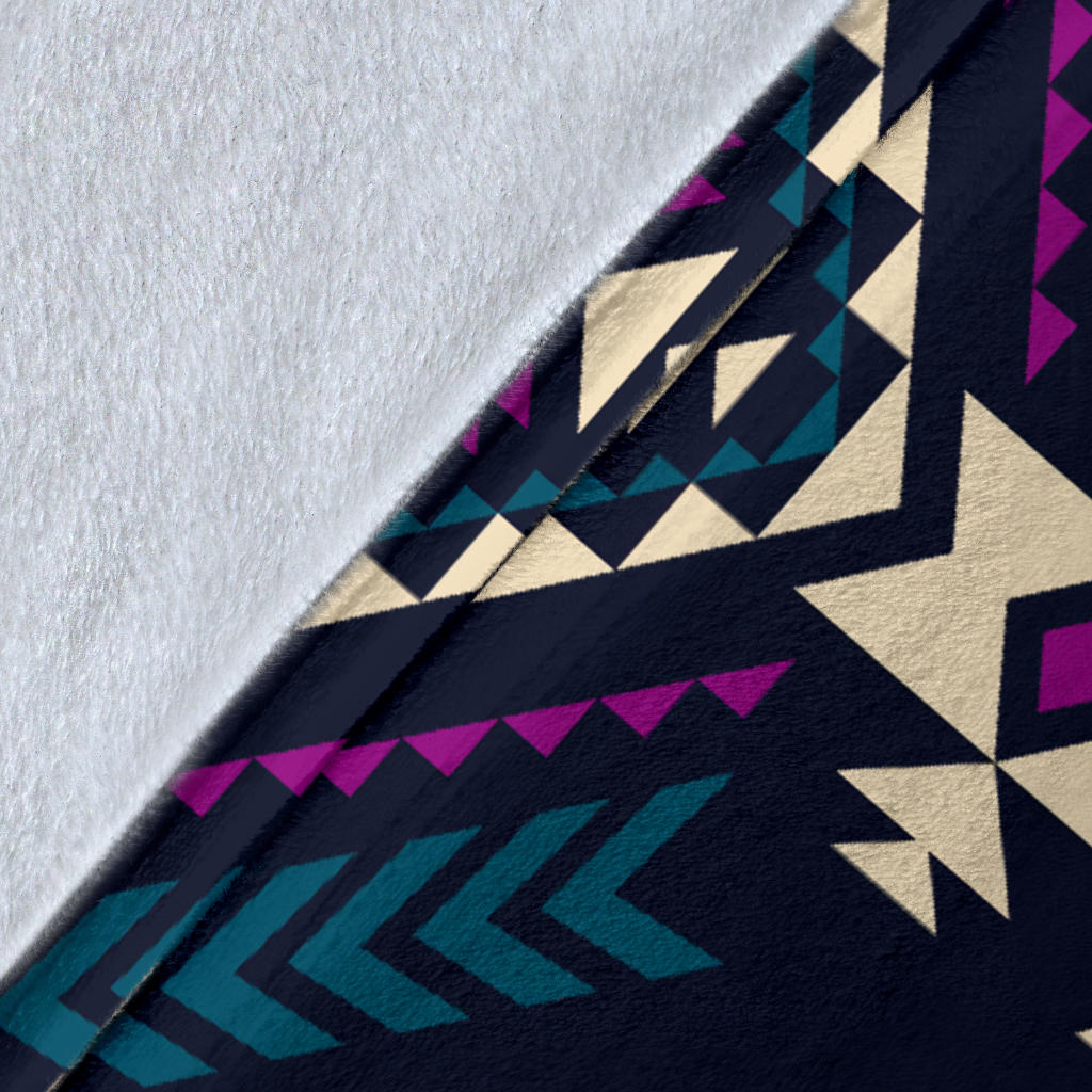 Close-up of dark tribal geometric blanket texture with teal, purple, and cream pattern
