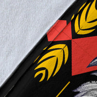 Close-up of blanket fabric, black with yellow geometric lines and red accents