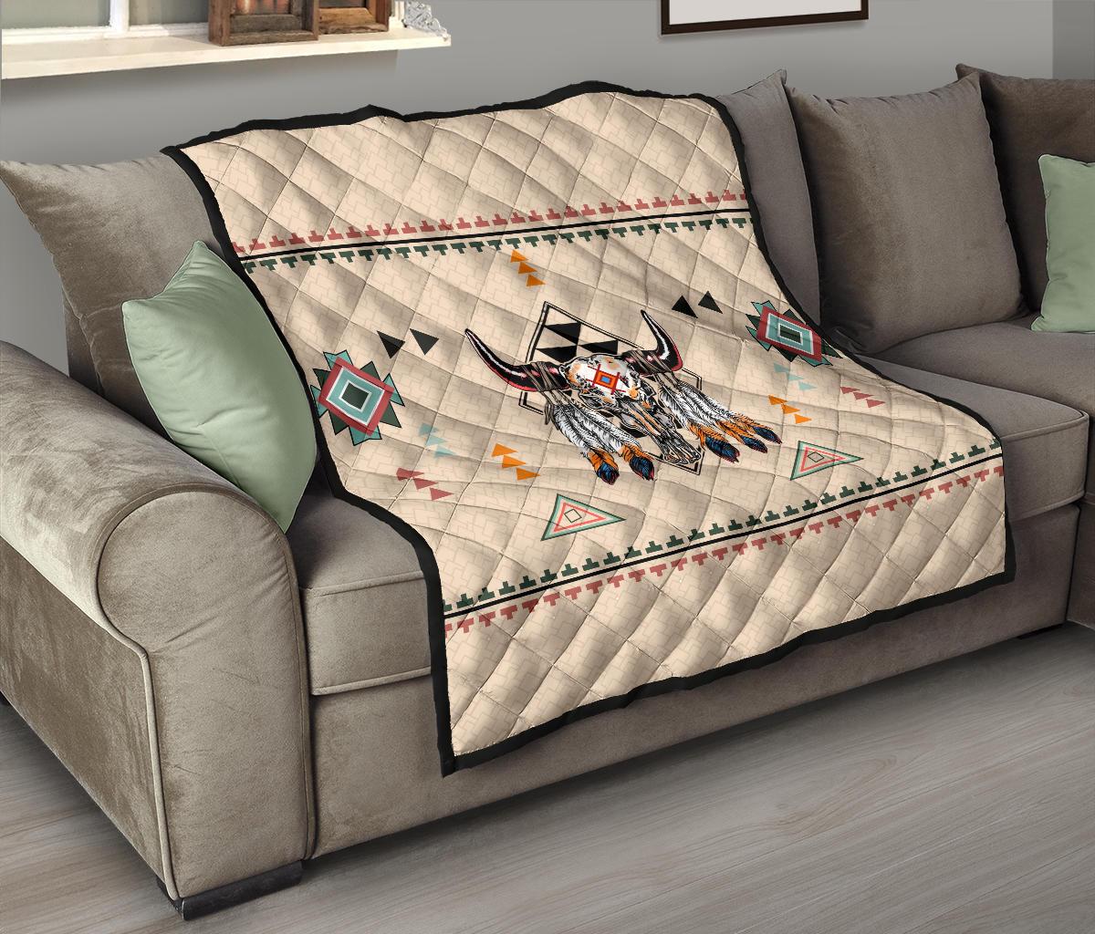 Bison quilt thrown over sofa; cream background with multicolor geometric motifs