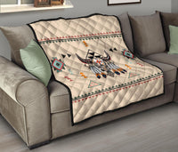 Bison quilt thrown over sofa; cream background with multicolor geometric motifs