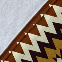 Close-up of brown blanket fabric with geometric zigzag triangles and diamond pattern