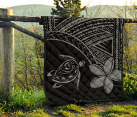Hawaiian quilt outdoors: black base with grey turtle and plumeria flower, patterned border