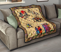 Quilt draped over a sofa, multicolor Native-style artwork with black border and beige center