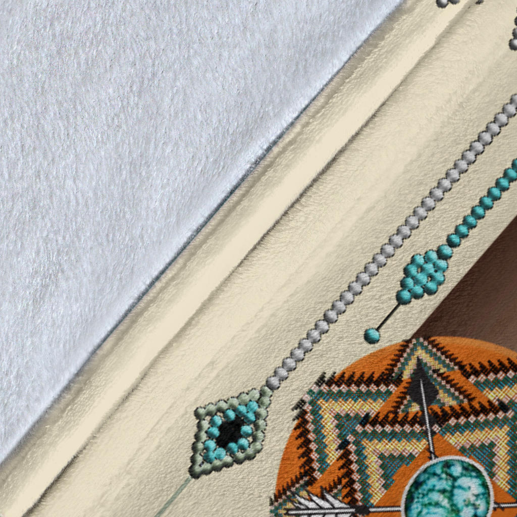 Blanket border close-up with teal beaded trim and orange geometric medallion