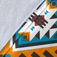 Close-up of Aztec geometric blanket fabric, teal and orange stripes with navy shapes on white