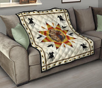 Quilt laid on gray sofa: white background, chief profile starburst, black horses and birds border