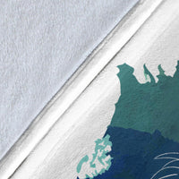 Close-up of blue and green dream catcher blanket fabric, teal web pattern on white