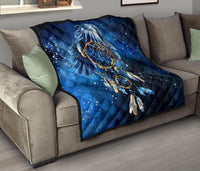 Blue galaxy dreamcatcher throw quilt on sofa, navy diamond quilting and feather motif