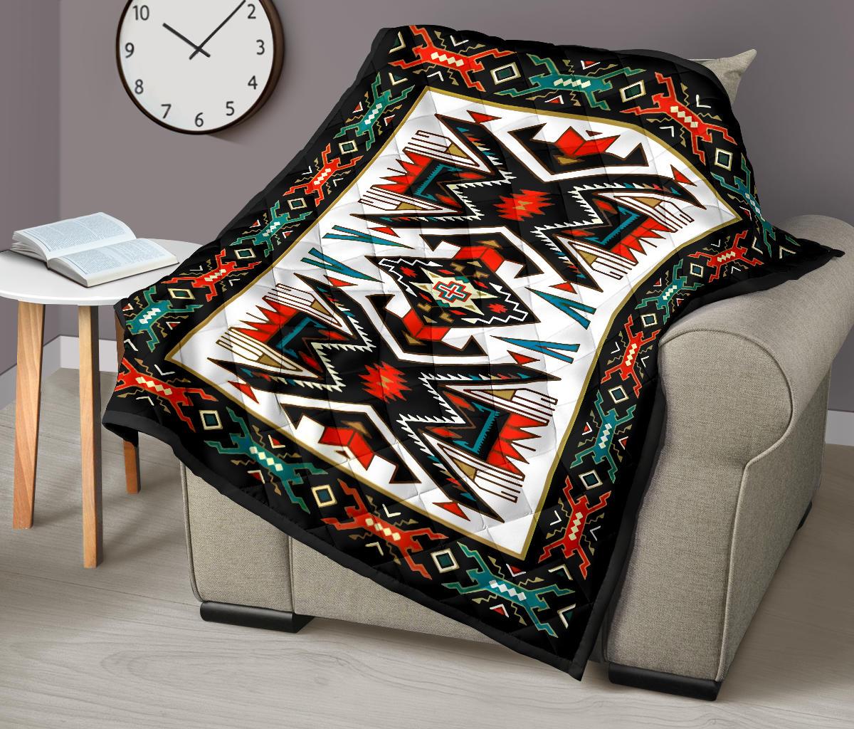 Geometric quilt over sofa, black border with red, green, teal, and white Native American motif