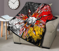 Bison skull quilt with multicolor arrow rays, shown spread over a beige chair