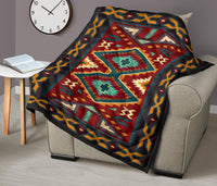 Native American-style quilt draped over armchair with central teal diamond and red accents