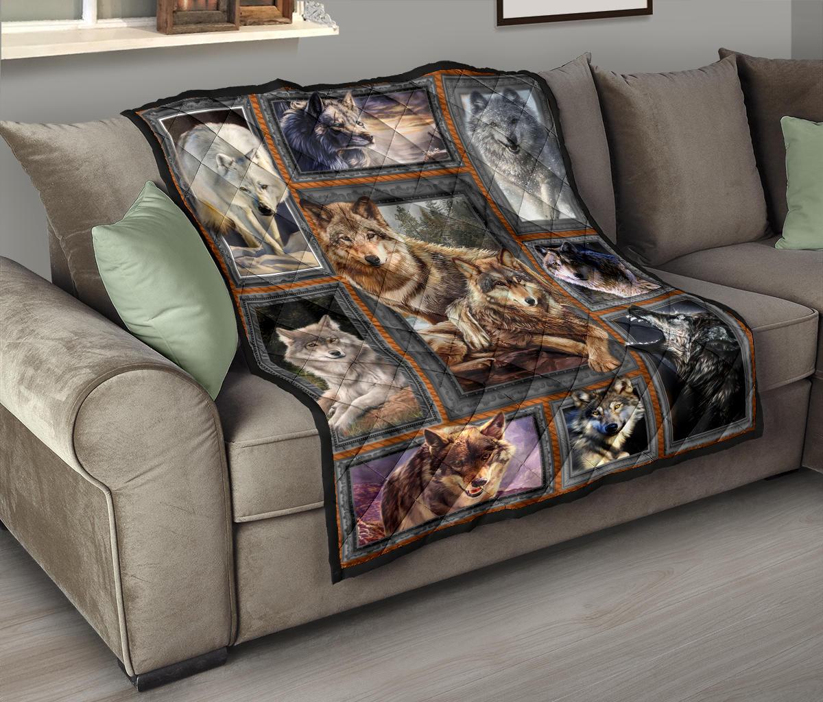 Wolf quilt over sofa, nine framed wolf portraits in multicolor with dark stitched border
